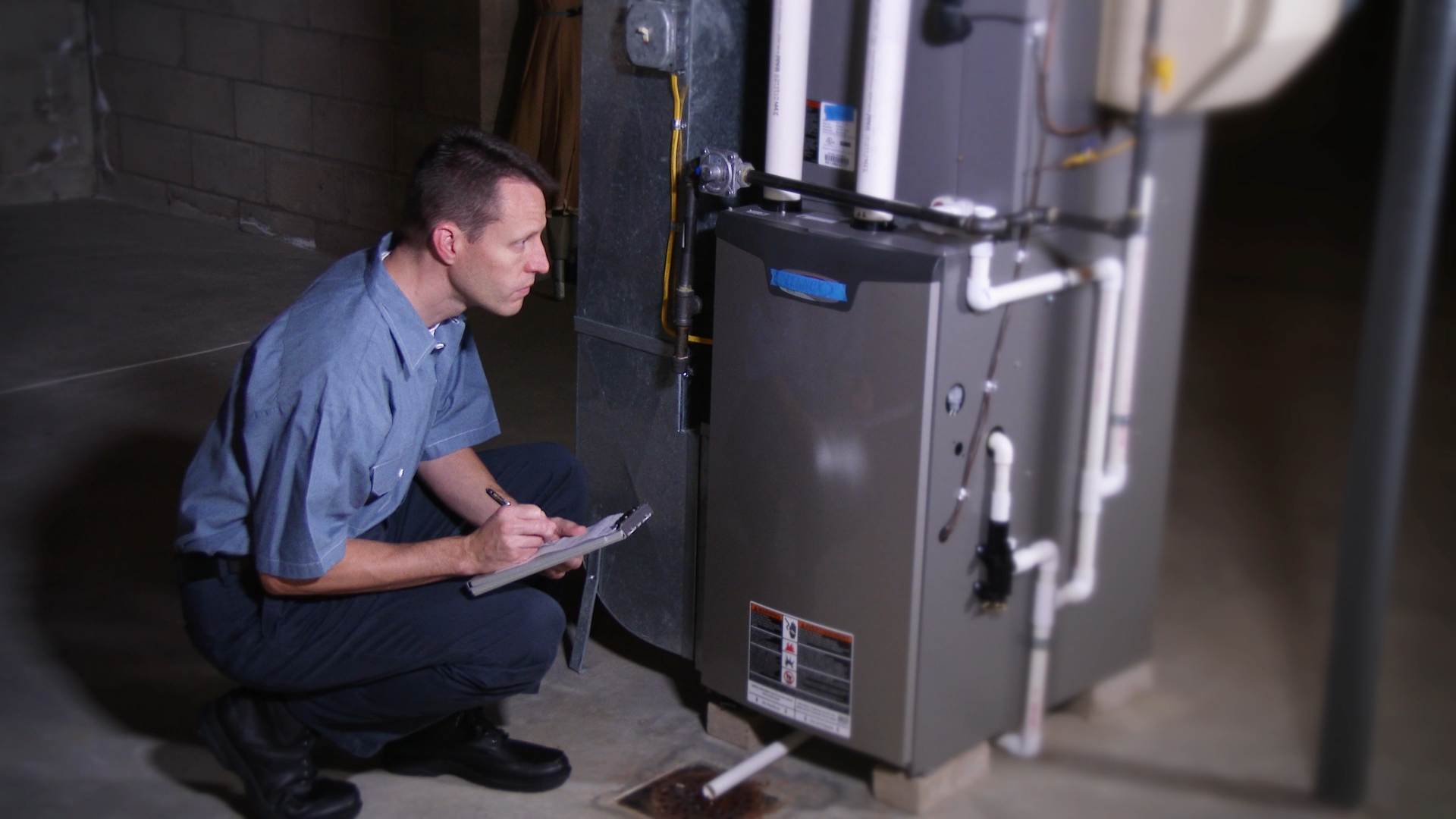 Furnace Tune-Up Service man looking at heater for winter furnace tune up